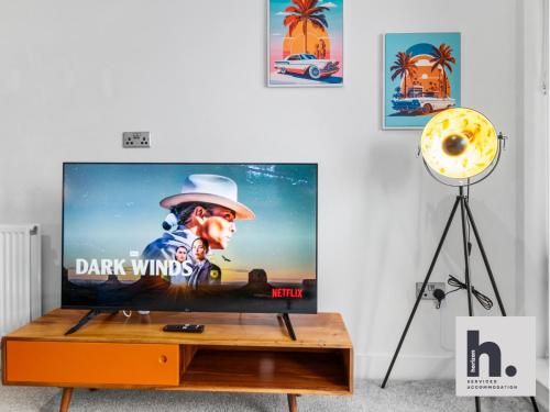 a flat screen tv sitting on top of a wooden table at Contractors - Long Stay - City Centre - Free Parking - Balcony in Hull