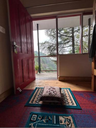 Habitación con puerta y alfombra en el suelo en Jaberkhet Trekkers Lodge, en Mussoorie