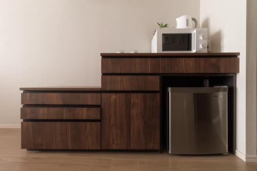 a microwave sitting on top of a wooden entertainment center at LANG HOTEL Kameido - Vacation STAY 76905v in Tokyo