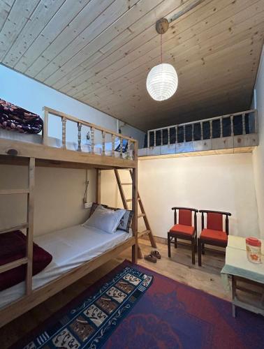 Una habitación con literas y una mesa y sillas. en Jaberkhet Trekkers Lodge, en Mussoorie