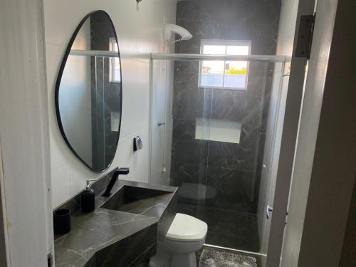 Un baño con lavabo, inodoro y espejo. en Banheiro INDIVIDUAL, Garagem Coberta e TV com streamings, en Campo Mourão