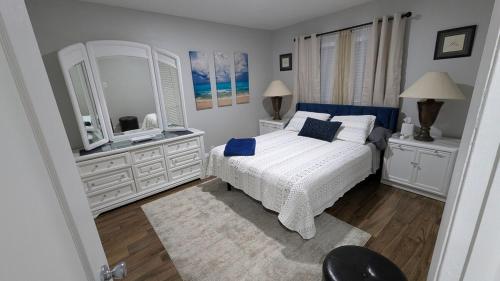 a bedroom with a white bed and a large mirror at Newly remodeled Near Midtown S Tampa Westshore in Tampa