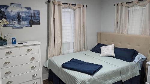 a bedroom with a bed with blue pillows and a dresser at Newly remodeled Near Midtown S Tampa Westshore in Tampa