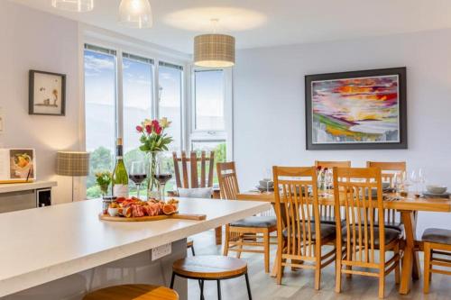 a kitchen and dining room with a table and chairs at Foinaven House in Ullapool