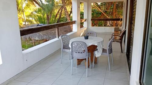 a table and chairs on the porch of a house at Jardim Azul Praia in Pitimbu