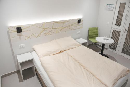 a white room with a bed and a table at C&M Hotel in Hamburg