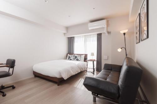 a bedroom with a bed and a couch and a chair at LANG HOTEL Kameido - Vacation STAY 79042v in Tokyo