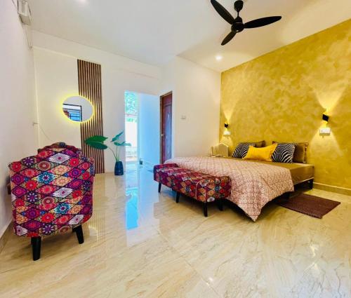 a bedroom with a bed and a couch and a chair at Mitra Palolem in Canacona