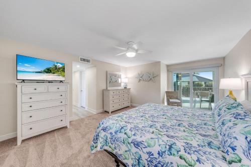 a bedroom with a bed and a dresser with a tv at Island Beach Club #320E in Sanibel