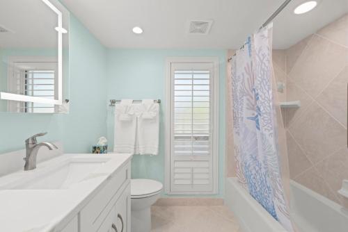 a white bathroom with a sink and a toilet at Island Beach Club #340E in Sanibel
