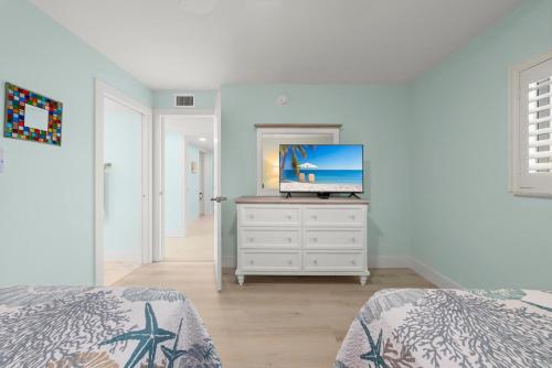 a bedroom with a dresser with a television on it at Island Beach Club #340E in Sanibel
