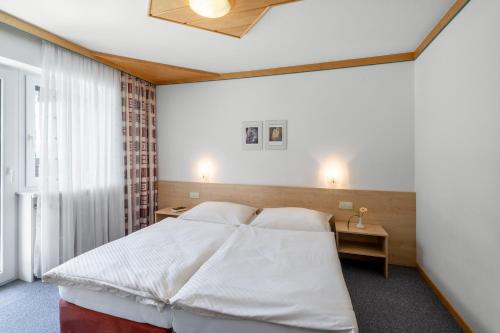 卡普伦Appartement Nr 12 Haus Voglreiter的卧室里有一张白色的大床和一张桌子
