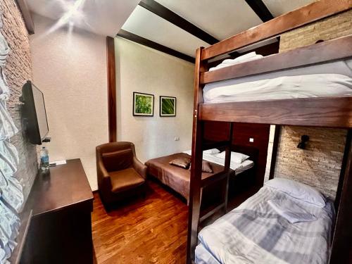 a room with bunk beds with a desk and a chair at Petrani Central in Kyiv