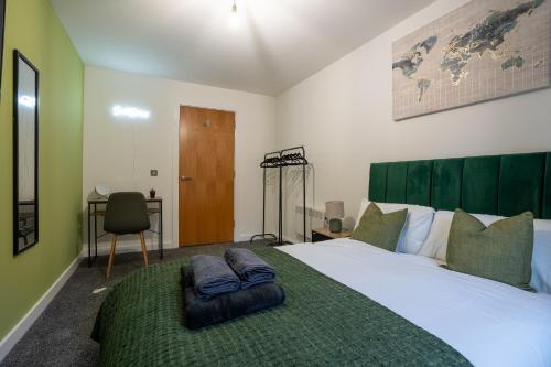 een slaapkamer met een groot bed met een groen hoofdeinde bij Spacious 2BR Apt - City Centre - Balcony - Parking in Central Station