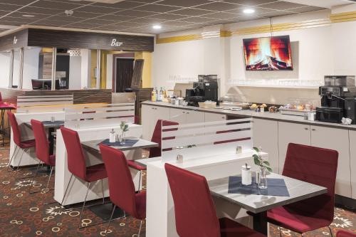 a restaurant with tables and chairs and a counter at C&M Hotel in Hamburg