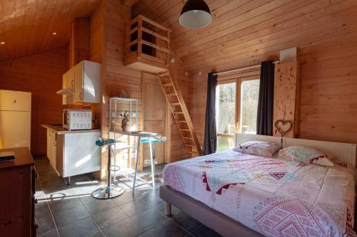 una camera da letto con un letto in una cabina di legno di Studio en Bois avec jardin clos a Bullion