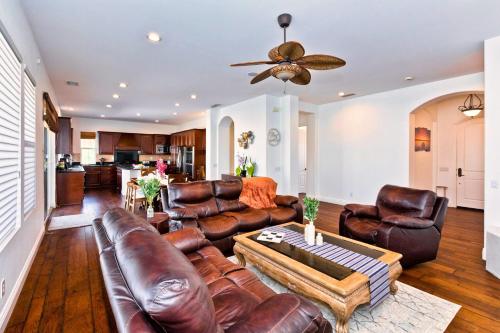 a living room with leather furniture and a ceiling fan at Poolside Bliss with elegant living #1 Rated in Palm Desert