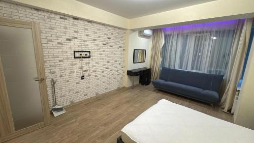 a living room with a blue couch and a brick wall at Wohnung Alter Hof in Künzell