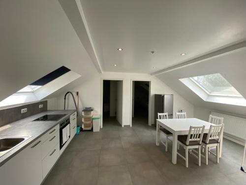 eine Küche mit Spüle und Tisch mit Stühlen in der Unterkunft OWL Comfort Homes - Porta Westfalica in Porta Westfalica