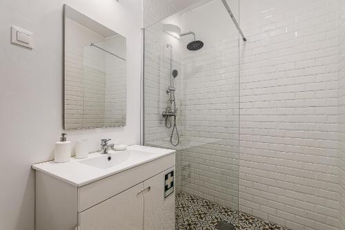 a white bathroom with a sink and a shower at Historic District lll in Alcácer do Sal