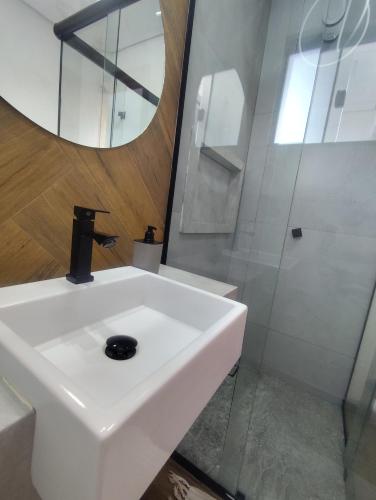 a bathroom with a white sink and a mirror at Suíte 12 dupla com vista para o mar in Pontal do Paraná