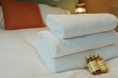 a pile of towels and two bottles of honey on a bed at Studio Flat Close to Queen Square - Flat 5B in Bristol