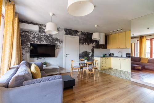 a living room with a couch and a kitchen at SPA Waterlane Island Deluxe 1 by Grand Apartments in Gdańsk