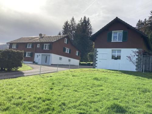 a house with a grassy yard in front of a house at Im Toggi in Wattwil