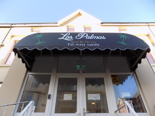 ein Restaurant mit schwarzer Markise auf einem Gebäude in der Unterkunft Palm Beach Hotel by the Sea in Blackpool