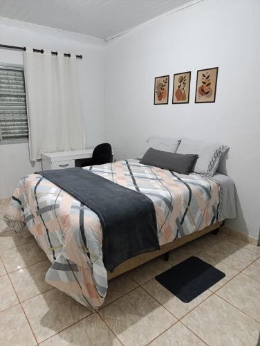 une chambre blanche avec un lit et un bureau dans l'établissement Pousada da Cervejaria FAGATA, à Monteiro Lobato