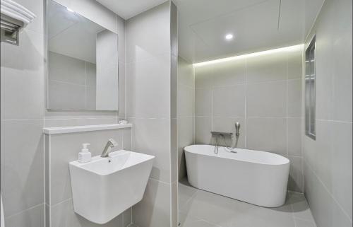 Un baño blanco con lavabo e inodoro. en aiden, en Busan