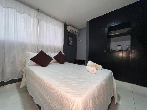 a bedroom with a large white bed with brown pillows at Aloha Rodadero in Gaira