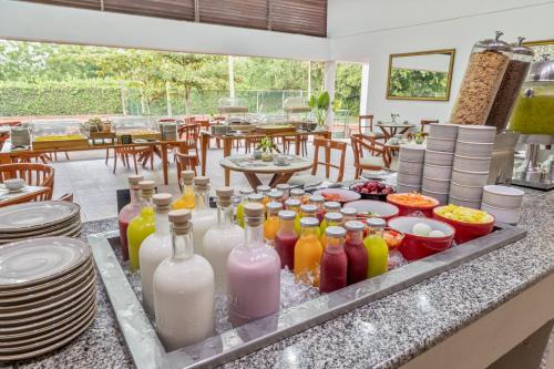 una mesa con muchas botellas de bebidas en la barra en GHL Hotel Club el Puente, en Girardot