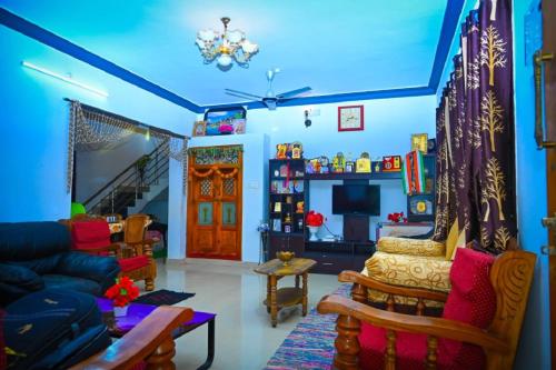 a living room with blue walls and a blue ceiling at Green Palaces Homestay in Avathi