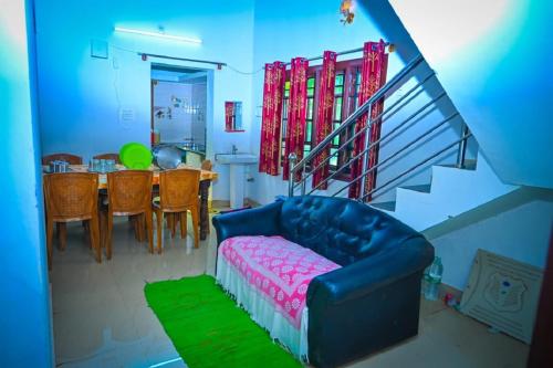 a living room with a blue couch and a table at Green Palaces Homestay in Avathi