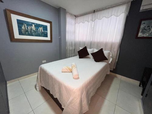 a bedroom with a bed with two towels on it at Aloha Rodadero in Gaira