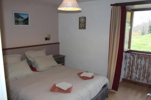 ein Schlafzimmer mit einem Bett mit zwei Hüten darauf in der Unterkunft Gite Les Alberts - L'Estagnol in Arrens-Marsous