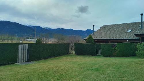 ein Hof mit einem Zaun und einem Haus und Bergen in der Unterkunft Casa Pepe Baltarga in Prats i Sansor