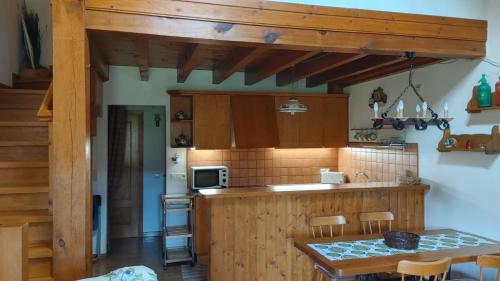 eine Küche mit Holzschränken und einem Tisch mit Stühlen in der Unterkunft Casa Pepe Baltarga in Prats i Sansor