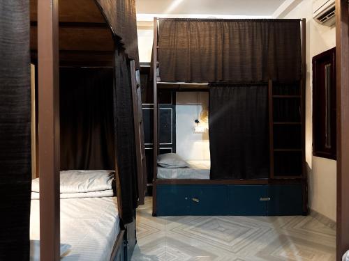 a room with two bunk beds and a mirror at Mosaic Hostel Varanasi in Varanasi