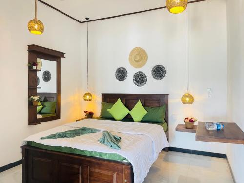 ein Schlafzimmer mit einem großen Bett mit grünen Kissen in der Unterkunft Winston ocean heaven in Negombo