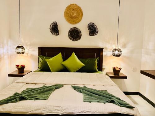 ein Schlafzimmer mit einem großen Bett mit grünen Kissen in der Unterkunft Winston ocean heaven in Negombo