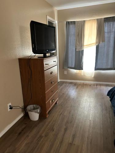 a living room with a tv on a dresser with a dresser at West Phoenix Value Room 3 Bennet in Phoenix