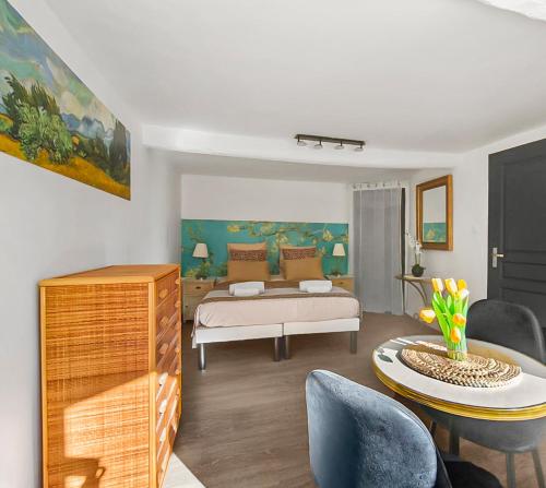 a living room with a bed and a table at Les Amandiers - L'Isle d'Or in LʼIsle-sur-la-Sorgue