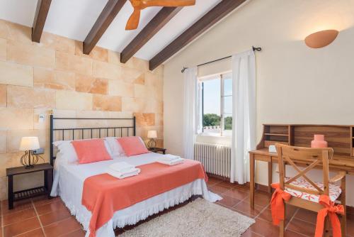 a bedroom with a bed and a desk and a window at Villa Mig Coster - Refugio rural en finca privada in Sant Lluis