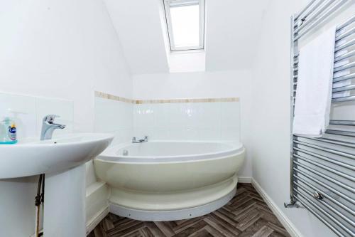 a white bathroom with a sink and a tub at Spacious 3-Bed Home – Family Contractor Friendly in Coxhoe