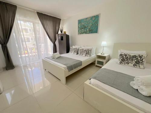 a bedroom with two beds and a window at SUMMER DREAM STUDIOS DELUXE playa LOS CORALES in Punta Cana