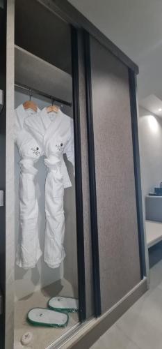 due abiti bianchi sono appesi a una parete di Aroma Hotel ad Aqaba