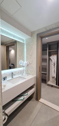 ein Badezimmer mit Waschbecken und großem Spiegel in der Unterkunft Aroma Hotel in Aqaba