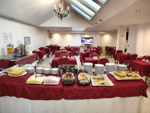 Un salón de banquetes con mesas cubiertas con manteles rojos y comida en Hotel Guerrero, en Mar del Plata